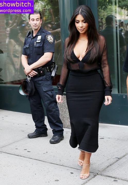 COP A VIEW! Kim Kardashian leaves her apartment with an NYPD officer appearing to stare at her backside